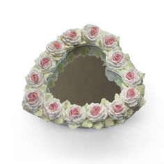 a heart shaped mirror with pink roses on it