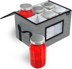 two jars with lids are sitting in the shape of a box that holds six jars