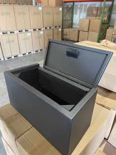 a large black box sitting on top of boxes in a room filled with other boxes