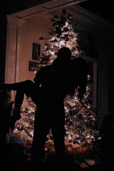 a person standing in front of a christmas tree