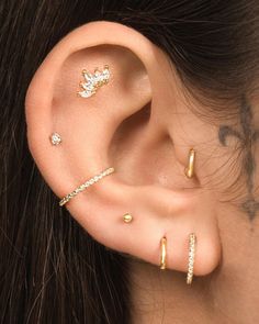 a close up of a person with ear piercings on their ears and behind the ear