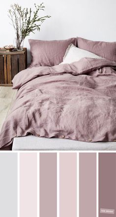 a bedroom with pink and grey colors on the walls, bed linens and pillows