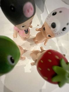 three small toy animals standing next to each other on top of a white countertop