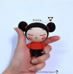 a hand holding a small crocheted doll in front of a white background with the word puca on it