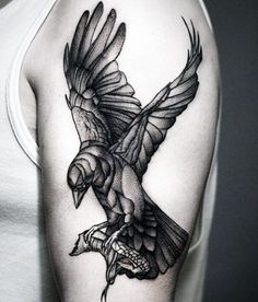 a black and white tattoo of a bird on the left upper half of the arm