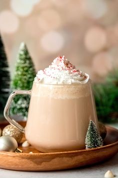 hot chocolate with whipped cream and sprinkles in a mug on a wooden tray