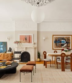 a living room filled with furniture and a fire place under a chandelier above a fireplace