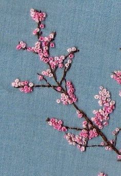 pink flowers are embroidered onto a blue background