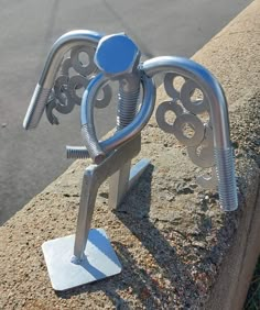 a metal sculpture sitting on top of a cement slab