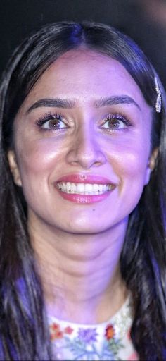 a close up of a person with long hair and wearing a tiara smiling at the camera