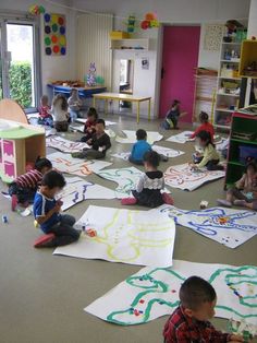 children are sitting on the floor drawing with crayons