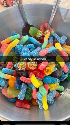 a bowl full of gummy bears with spoons in it and the words candy salad on