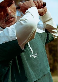 an older man holding a golf club in his right hand