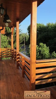 a wooden porch with railings and lights on it