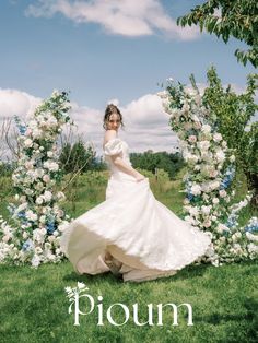 a woman in a wedding dress standing under an arch of flowers with the word pioni on it