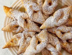 a white plate topped with pastries covered in powdered sugar