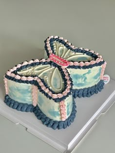 two decorated cakes sitting on top of a white box