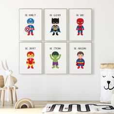 four children's art prints featuring superheros and their names are displayed on the wall