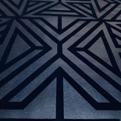 an abstract black and white design on the floor in a room that is very dark