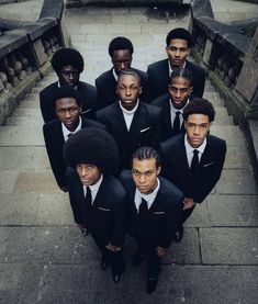 a group of young men in suits and ties posing for a photo on some steps