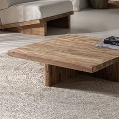 a wooden coffee table sitting on top of a rug