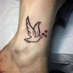 a small tattoo on the foot of a person with hearts flying in the sky above it