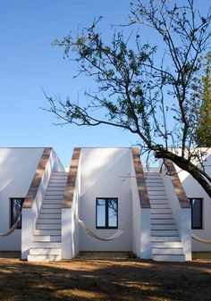 three white buildings with wooden steps and windows