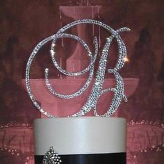 a black and white wedding cake with the letter b on it's top tier