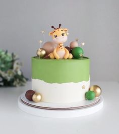 a green and white cake with a giraffe topper sitting on it's side