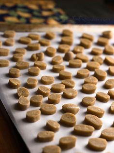 there are many small pieces of food on the trays that is ready to be baked