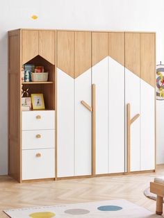 a child's room with white cupboards and wooden furniture, including a bookcase