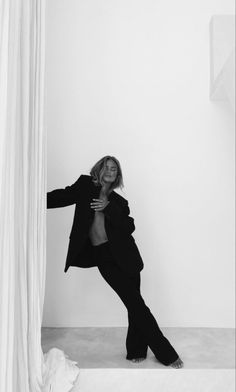 a black and white photo of a woman leaning against a wall