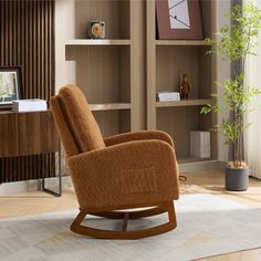 a living room with a rocking chair and bookshelf in the corner, next to a potted plant