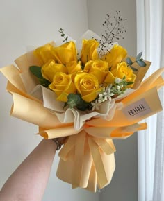 a person holding a bouquet of yellow roses