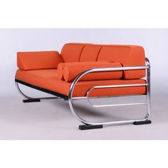 an orange couch sitting on top of a metal frame with two arms and one arm extended