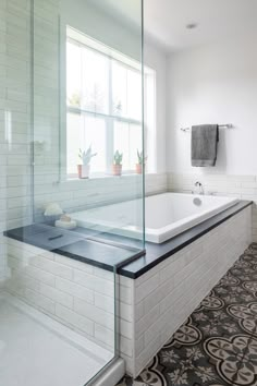 a bath tub sitting next to a window in a bathroom