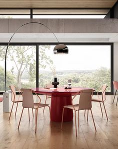 a dining table with chairs around it in front of a large window overlooking the countryside