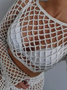 a woman wearing white mesh clothing with her hands on her hips