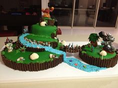 a cake made to look like an island with trees and animals on the top is sitting on a table in front of a window