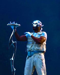 a man in white is holding a silver tray on his hand and wearing a mask