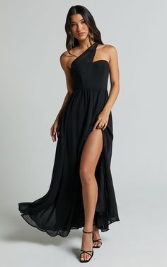 a woman wearing a black one shoulder dress with thigh high slits and an asymmetrical neckline