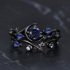 a ring with blue stones and leaves on it