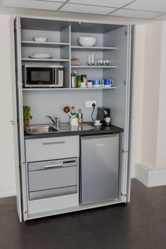 a small kitchen with a dishwasher, sink and microwave in the cupboards