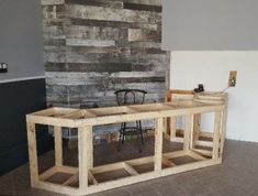 a table made out of wooden planks in front of a wood paneled wall