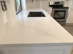 a kitchen with white counter tops and stainless steel stove top oven in the center island