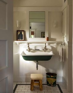 a bathroom with a sink, mirror and stool in it