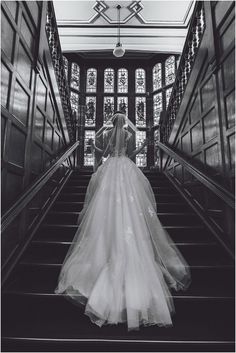 a woman in a wedding dress walking down some stairs