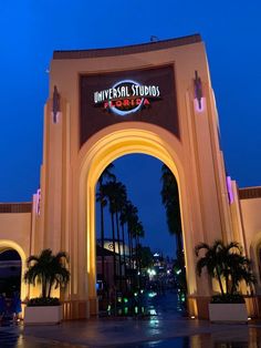 the entrance to universal studios is lit up at night