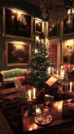 a christmas tree is lit in the middle of a room with paintings on the wall