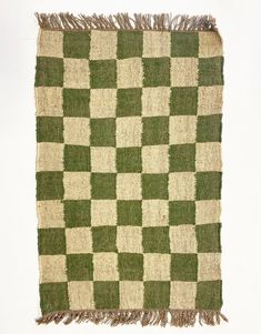 a green and white checkered rug with fringes